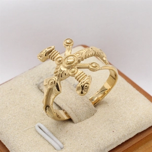 Macro detail of vintage gold steel ring featuring intricate embossed totem carvings
