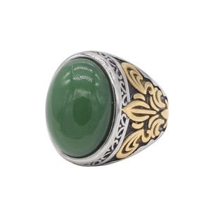 Nahaufnahme eines Vintage-Herrenrings mit ovalem grünen Edelstein und Goldakzenten