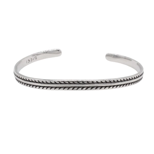 Detail view of silver men's cuff bracelet showing woven embossed texture and DICCI engraving