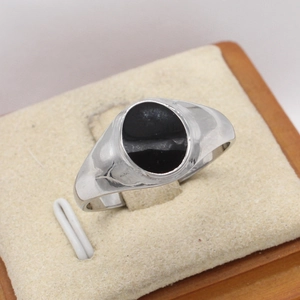 Bague minimaliste en acier titane avec onyx noir sur un présentoir bijoux