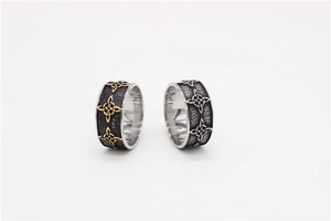 Detailed close-up of retro Celtic knot engravings on wide black steel rings for men