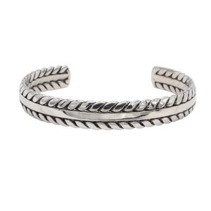 Macro shot of retro silver cuff bracelet with twisted rope texture and smooth metal inlay