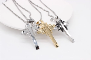Detailed top view of cross pendants in silver, gold, and black on a white display tray