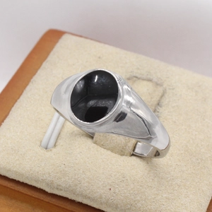 Gros plan sur une bague chevalière pour homme avec résine noire et boîte en velours