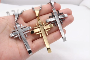 Detailed close-up of industrial style cross pendants in silver, gold and black finishes