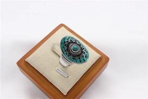 Dettaglio di un anello bohémien vintage con pietra turchese e motivi floreali neri