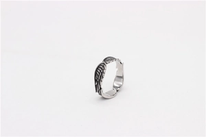 Detailed macro shot of vintage silver angel wing ring with black oxidized feather textures