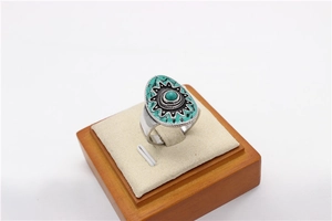 Dettaglio di anello boho vintage con pietra turchese verde e motivo etnico a raggiera