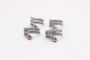 Detalle de anillo de serpiente plateado con textura de escamas y ojos de diamantes