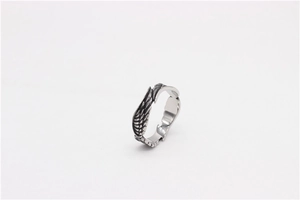 Detailed macro view of vintage angel wing feather texture on a steel ring for men