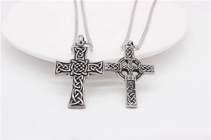 Gros plan de pendentifs croix celtique en argent vintage avec textures de métal noirci