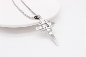 Macro detail of brushed stainless steel cross pendant with layered geometric metal bars
