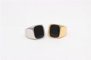 Detailed view of square black gemstone signet rings in gold and silver finishes