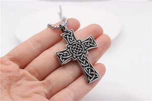 Détail du pendentif croix celtique en argent vintage avec motifs tressés et chaîne à maillons