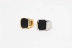 Detail showing silver and gold rectangle black gemstone rings on white background