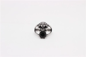 Gothic skull ring featuring a faceted black gemstone in its mouth, macro detail