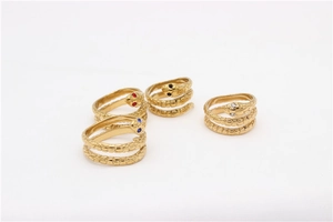 Detalle de cuatro anillos de serpiente dorados con escamas y ojos de gemas de colores