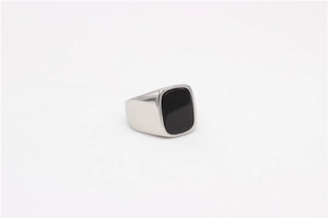 Detailed macro view of men's titanium steel signet ring with a black square gemstone