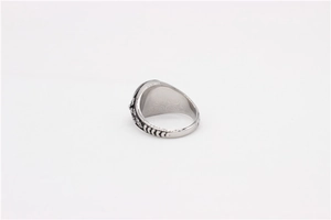 Macro detail of vintage stainless steel signet ring with embossed floral patterns