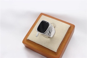 Macro shot of silver men's signet ring with rectangular black onyx stone inlay