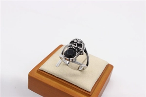 Close-up of retro skull ring in titanium steel featuring a round black gemstone inlay