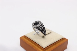 Macro detail of retro steel ring with black gemstone and engraved Winchester bullet base