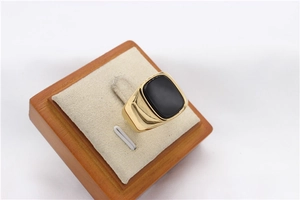 Macro shot of men's gold plated signet ring with rectangular black onyx stone inlay