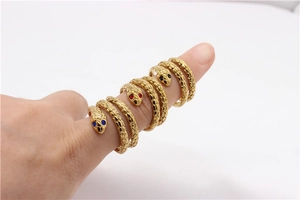 Detalle de anillos de serpiente con escamas doradas y ojos de piedras preciosas de color
