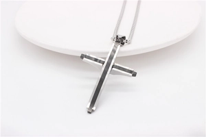 Vue détaillée du pendentif croix en acier inoxydable argent et noir à design superposé