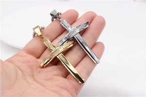Gros plan sur pendentif croix multicouche et chaîne box, options or et argent poli