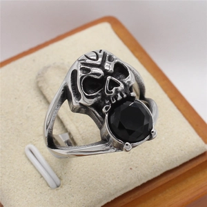 Retro gothic skull ring for men with large black round gemstone on wood display