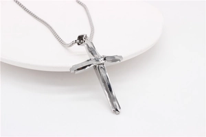 Vue détaillée du pendentif croix en acier titane poli avec un design géométrique moderne