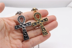 Close-up of gold and silver Ankh cross pendants with Egyptian hieroglyphs on chain