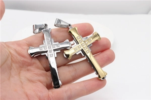 Vue rapprochée de grands pendentifs croix avec zircons sertis en acier argenté et or