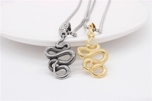 Macro shot of vintage snake pendants in gold and silver showing detailed scale textures