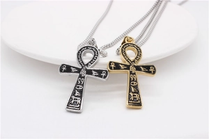 Detail of vintage Ankh cross pendants with intricate Egyptian hieroglyphics in silver and gold