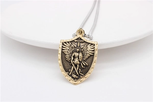 Gros plan du pendentif bouclier Saint-Michel avec relief détaillé en or rétro