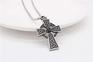Détail du pendentif croix celtique vintage avec pierre noire et motifs de nœuds complexes