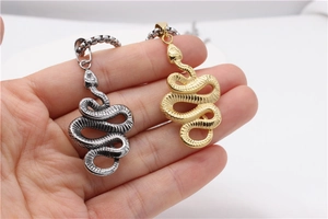 Macro shot of silver and gold serpent pendants featuring detailed scale engravings