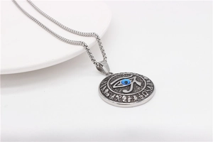 Nahaufnahme des silbernen Horusauge-Anhängers mit blauer Perle und ägyptischen Motiven