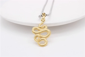 Detailed close-up of golden snake pendant with scales on silver snake bone chain