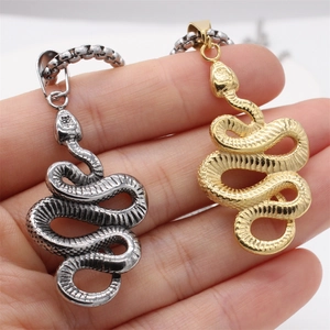 Retro snake pendants in gold and silver steel with detailed scale texture on hand