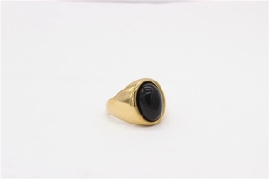 Gros plan d'une pierre précieuse noire ovale sur une bague chevalière dorée vintage