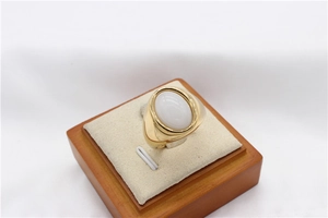 Détail d'une bague vintage en acier titane doré avec incrustation de gemme ovale blanche