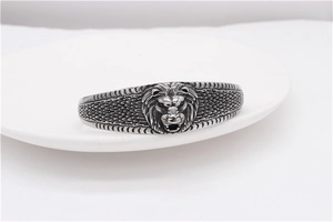 Macro detail of retro steel cuff bracelet with lion head carving and scale texture
