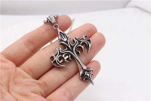 Macro detail of gothic cross pendant with vintage silver finish and flame carvings