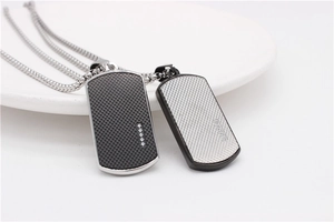 Detailed macro view of black and silver military tag pendants with grid pattern and stones