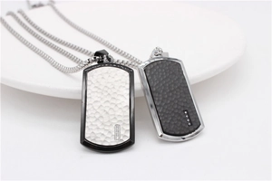 Detail view of hammered metal military dog tags with zircon stones on square box chain