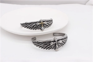 Close-up of vintage eagle wings and cross pattern on men's titanium steel cuff bracelets