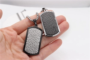 Detail of silver and dark grey military dog tags with honeycomb texture and tiny diamonds